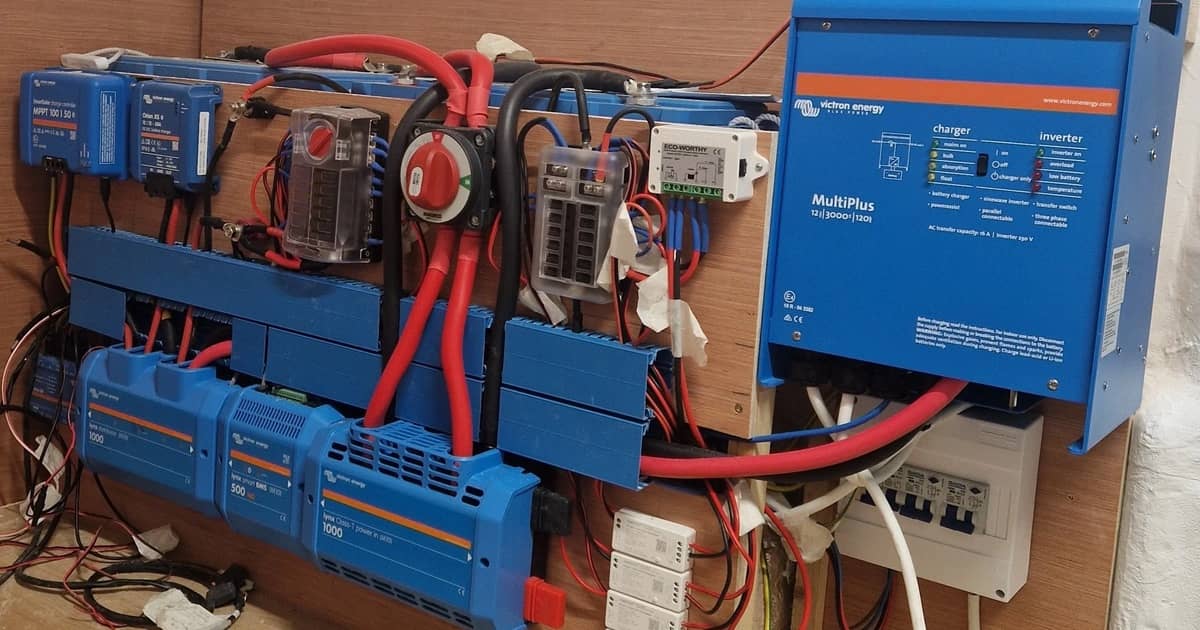 Victron inverter/töltő, napelemes töltésvezérlők és gyűjtősínek egy lakóautó falára szerelve